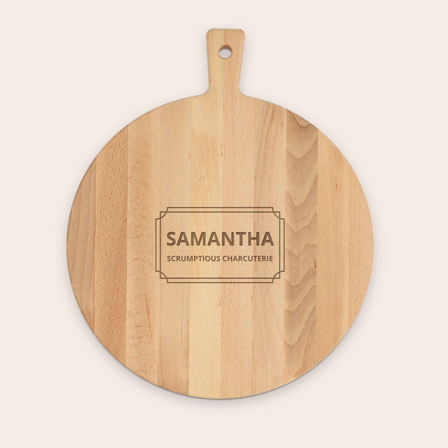 Tarjoilulaudat Pyöreä puinen tarjoilulautanen kaiverretulla nimellä "SAMANTHA" ja tekstillä "SCRUMPTIOUS CHARCUTERIE" kehystettynä.