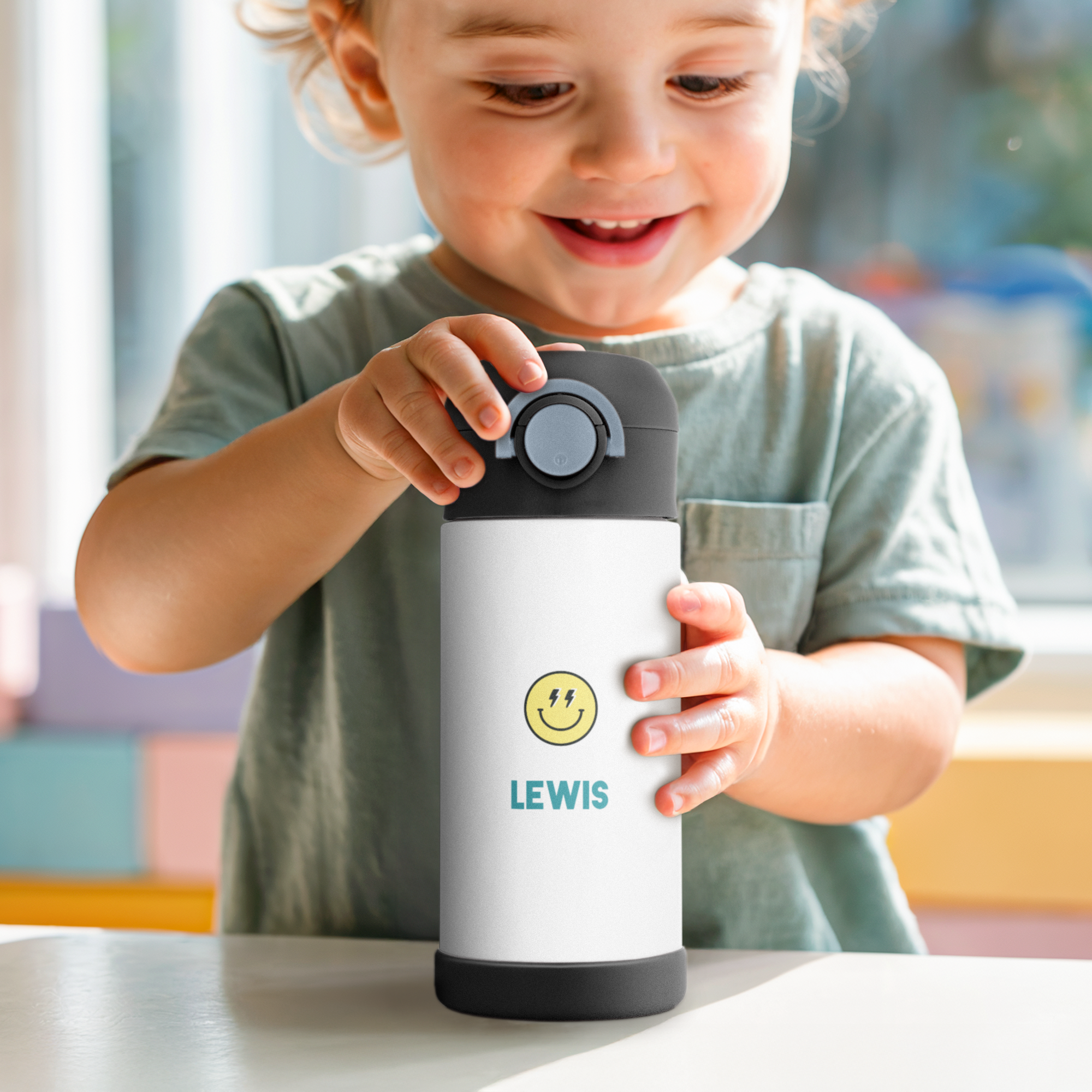 Bambino felice con bottiglia d'acqua in acciaio inossidabile personalizzata con nome Lewis e faccina sorridente stampata