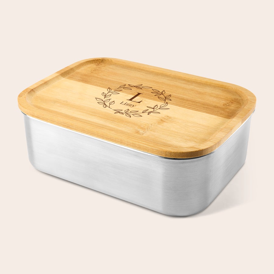 Personlig lunchbox Personlig lunchbox i rostfritt stål med bambulock, graverad med bokstaven L och namnet Lizzy omgivet av en krans.