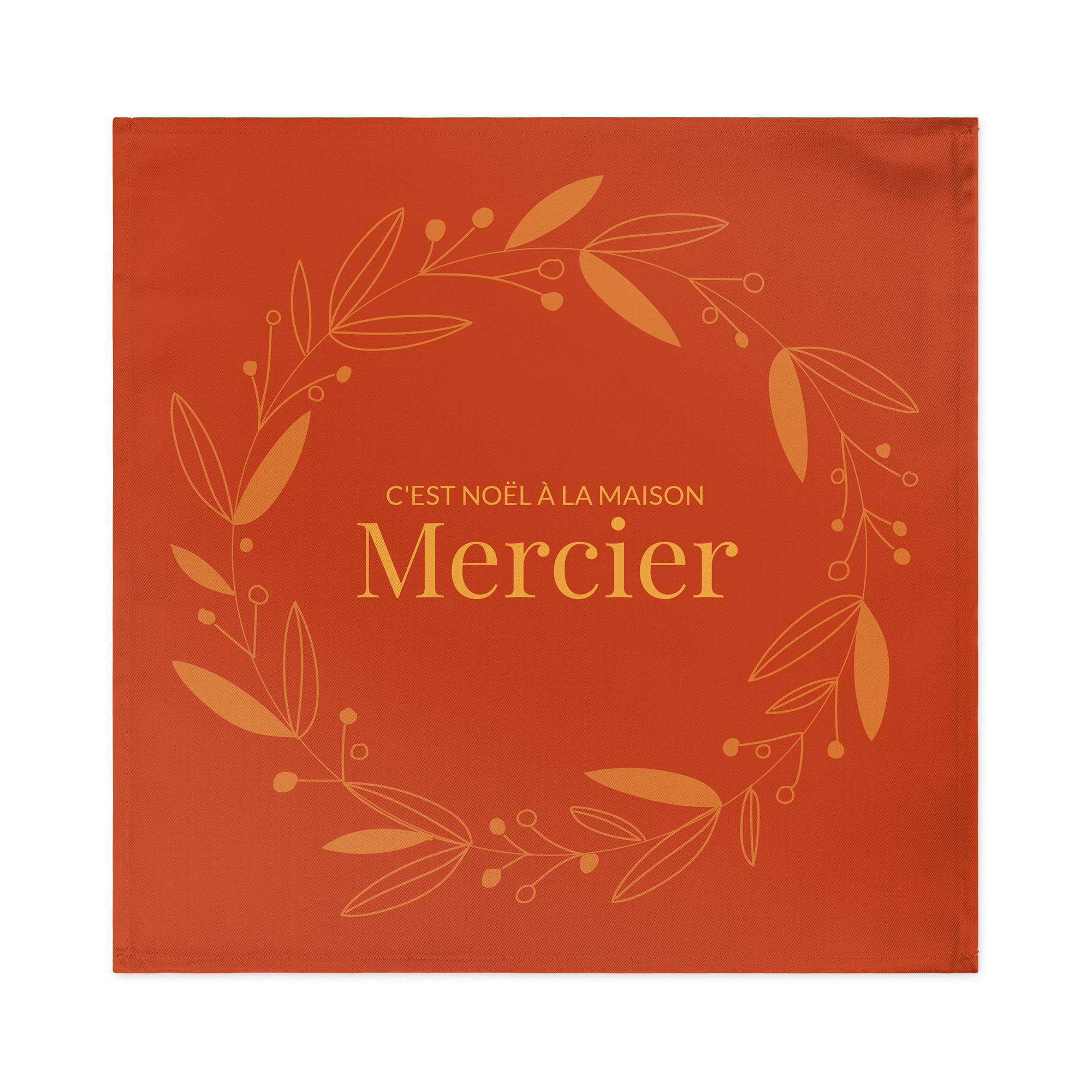 Serviette de table personnalisée orange imprimée d'une couronne végétale avec le texte C'EST NOËL À LA MAISON Mercier