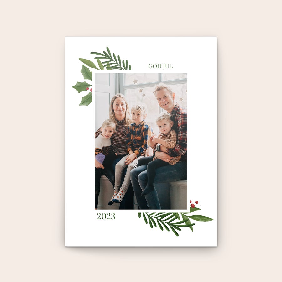 Gratulationskort - Jul Personligt gratulationskort med God Jul-text och ett familjefoto tryckt på kortet, omgivet av gröna blad och röda bär.