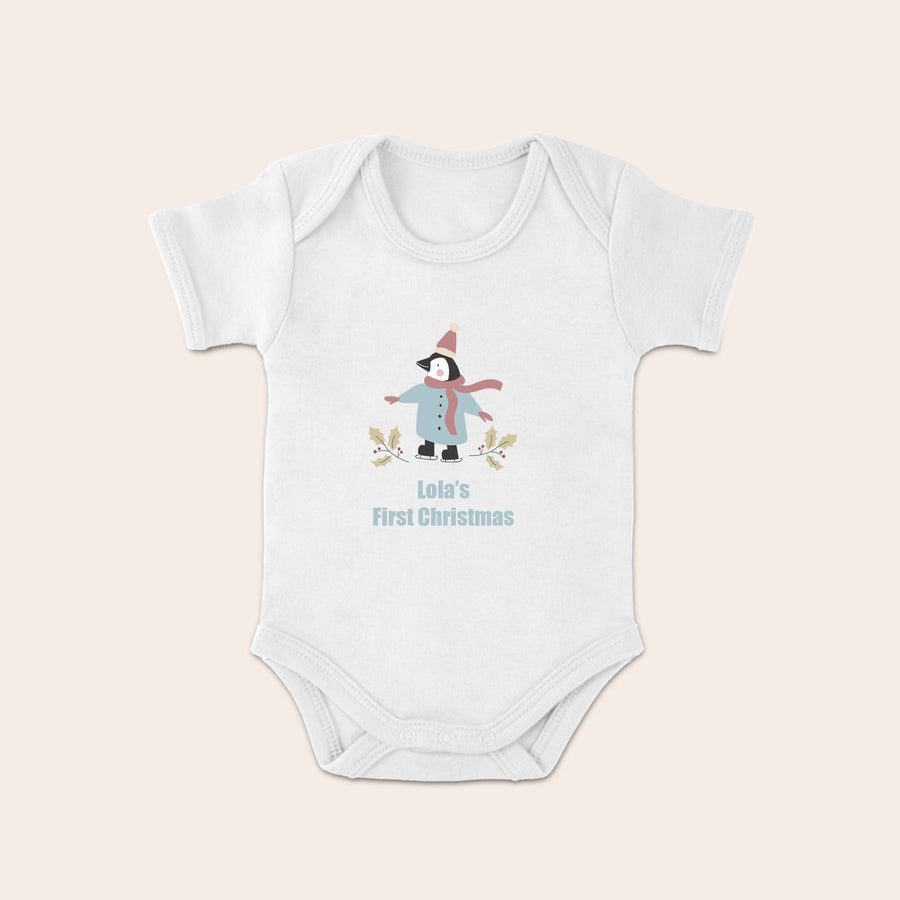 Baby's first Christmas Babygrow White Christmas babygrow with a printed skating penguin, holly, and the text Lolas First Christmas.