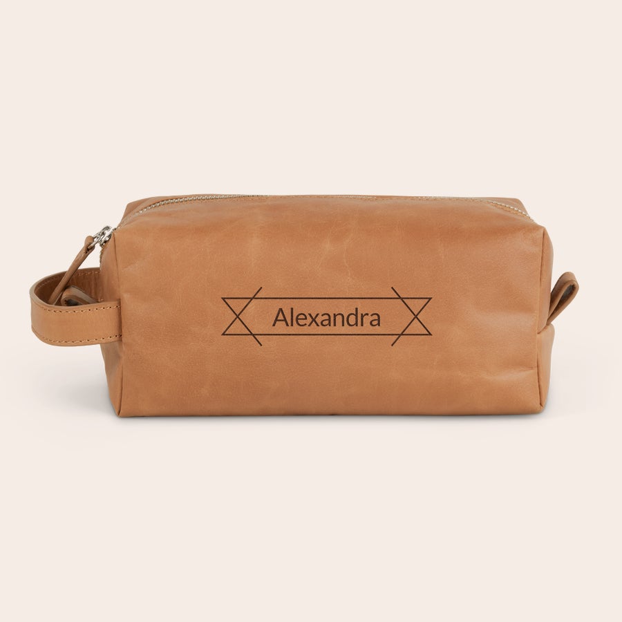 Grawerowana skórzana kosmetyczka Personalizowana skórzana kosmetyczka z grawerowanym imieniem Alexandra i ozdobnym wzorem. Rozpocznij dzień stylowo.