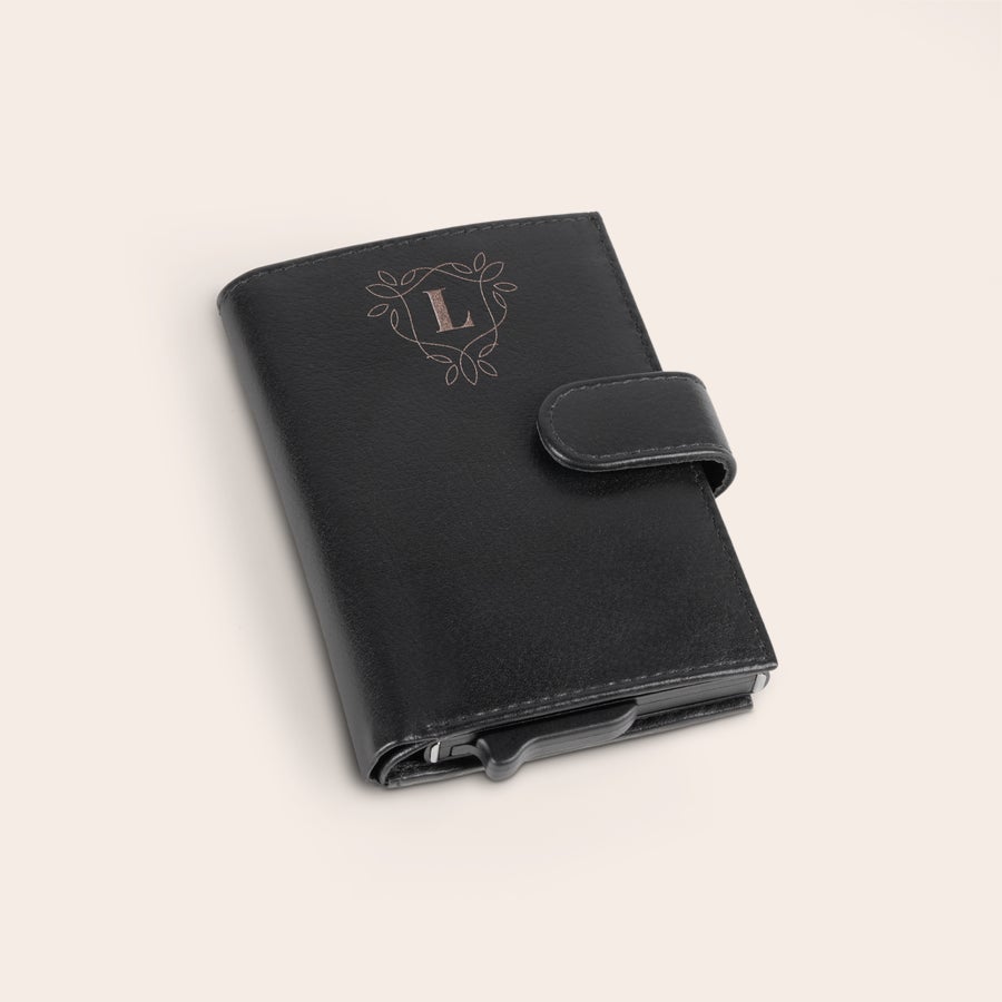 Titular de cartão personalizado Porta-cartões bancários de couro preto, gravado com a letra L dentro de um brasão floral personalizável.