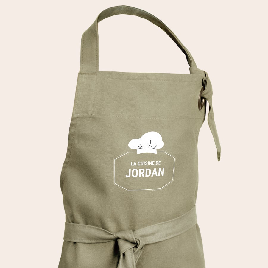 Tablier cuisine enfant personnalisé Tablier personnalisé pour enfants imprimé en beige avec un motif de toque de chef et "La cuisine de Jordan".