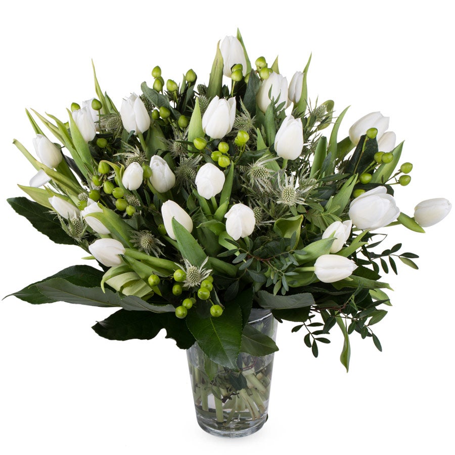 Boeket witte Bloemen – Tulpen in glazen vaas met groene bladeren en bessen, gepersonaliseerd te bestellen.