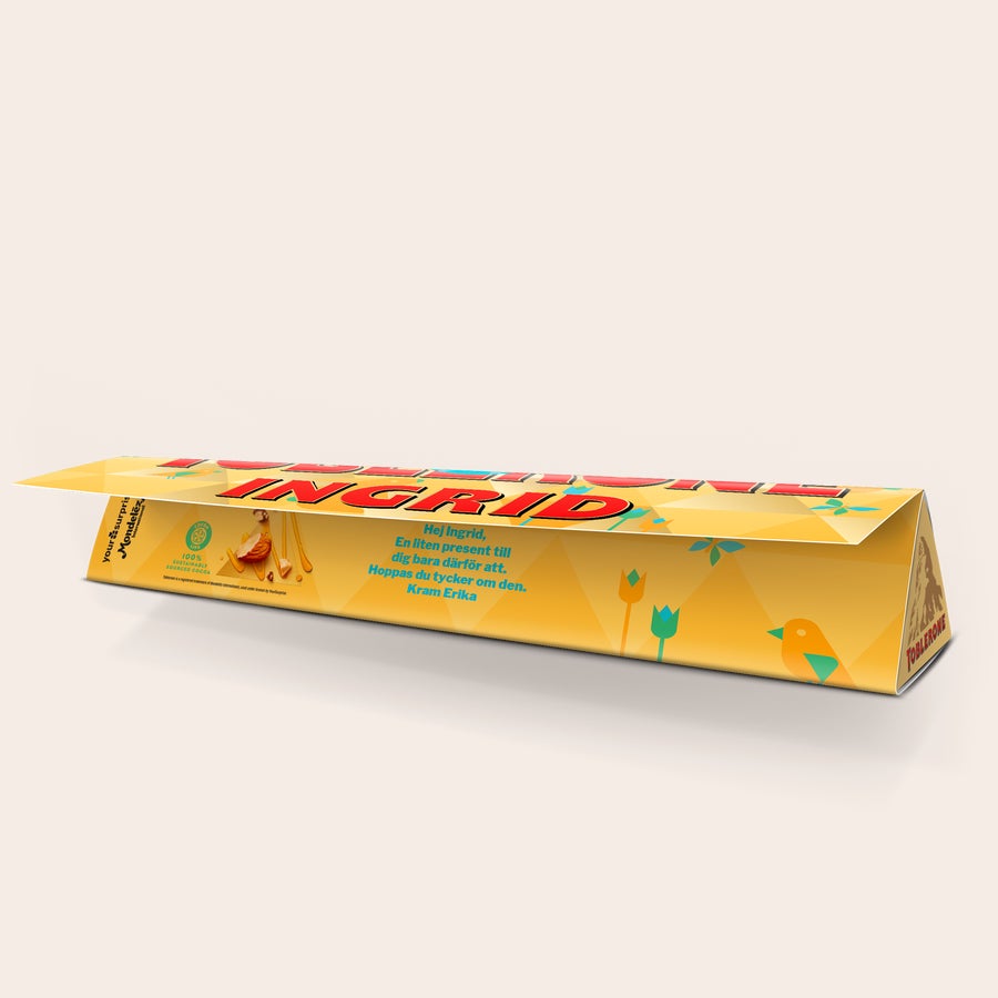 Toblerone Påskchoklad med namn och foto Toblerone med påskmotiv, namnet Ingrid och texten "Hej Ingrid, en liten present till dig bara därför att. Kram Erika" tryckt på förpackningen.