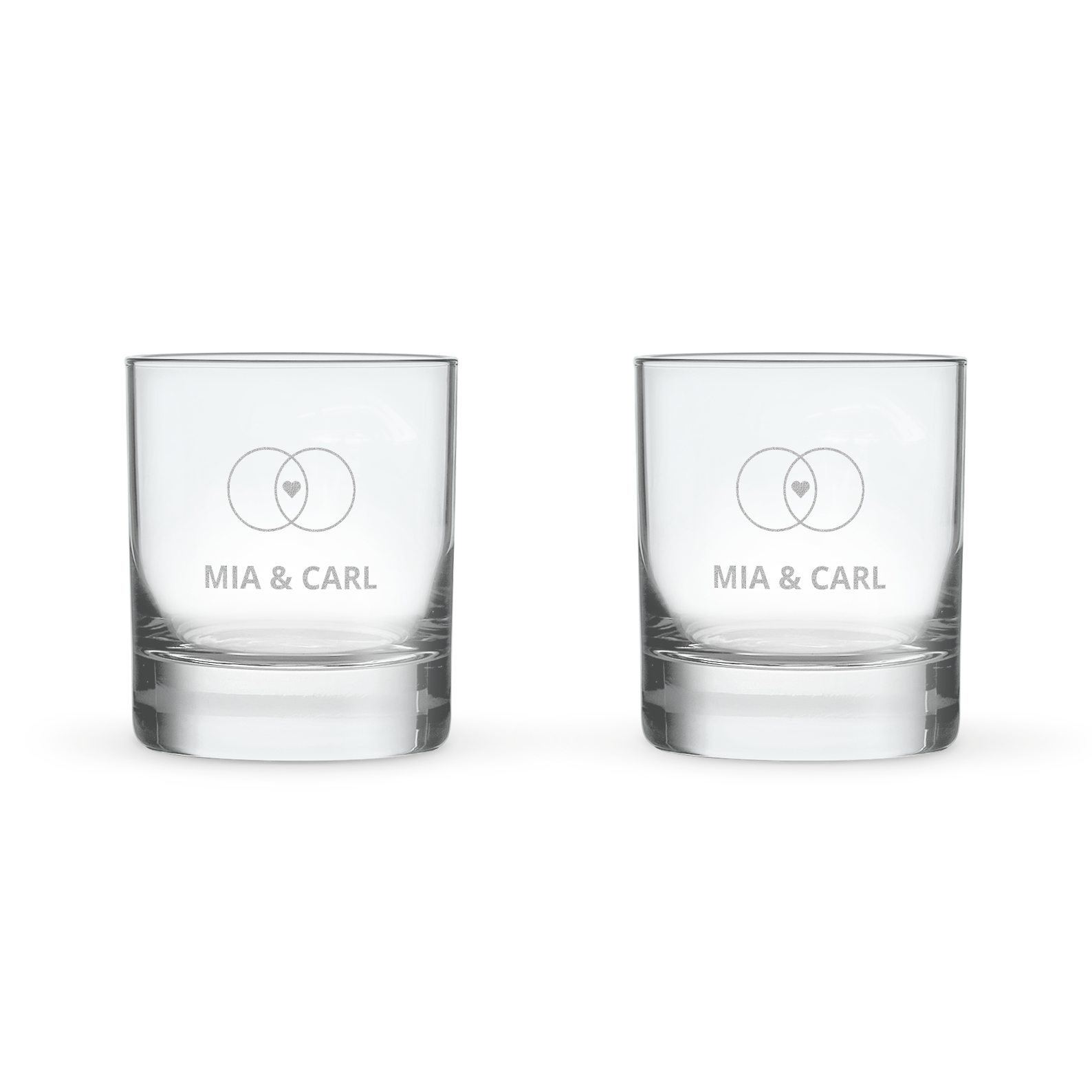 To personlige indgraverede whiskyglas med navnene Mia & Carl og et hjerte indgraveret i to ringe.