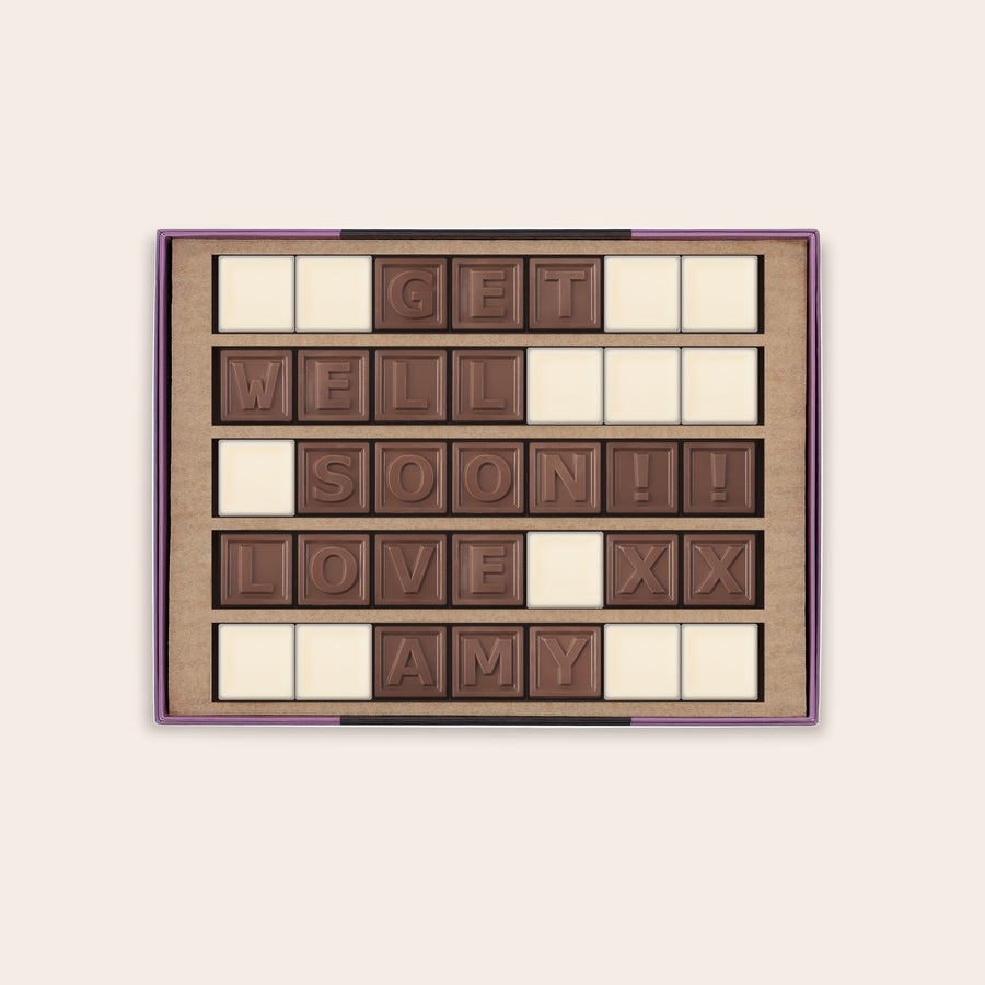 Chokladtelegram Ditt personliga chokladtelegram i en lila ask med mjölkchokladbokstäver som stavar "GET WELL SOON!! LOVE XX AMY" och vita chokladrutor som fyller ut