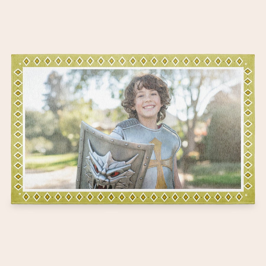 Speelkleed bedrukken Gepersonaliseerd speelkleed met foto van lachende jongen in ridderpak, geprint met een geel/witte ruitjesrand