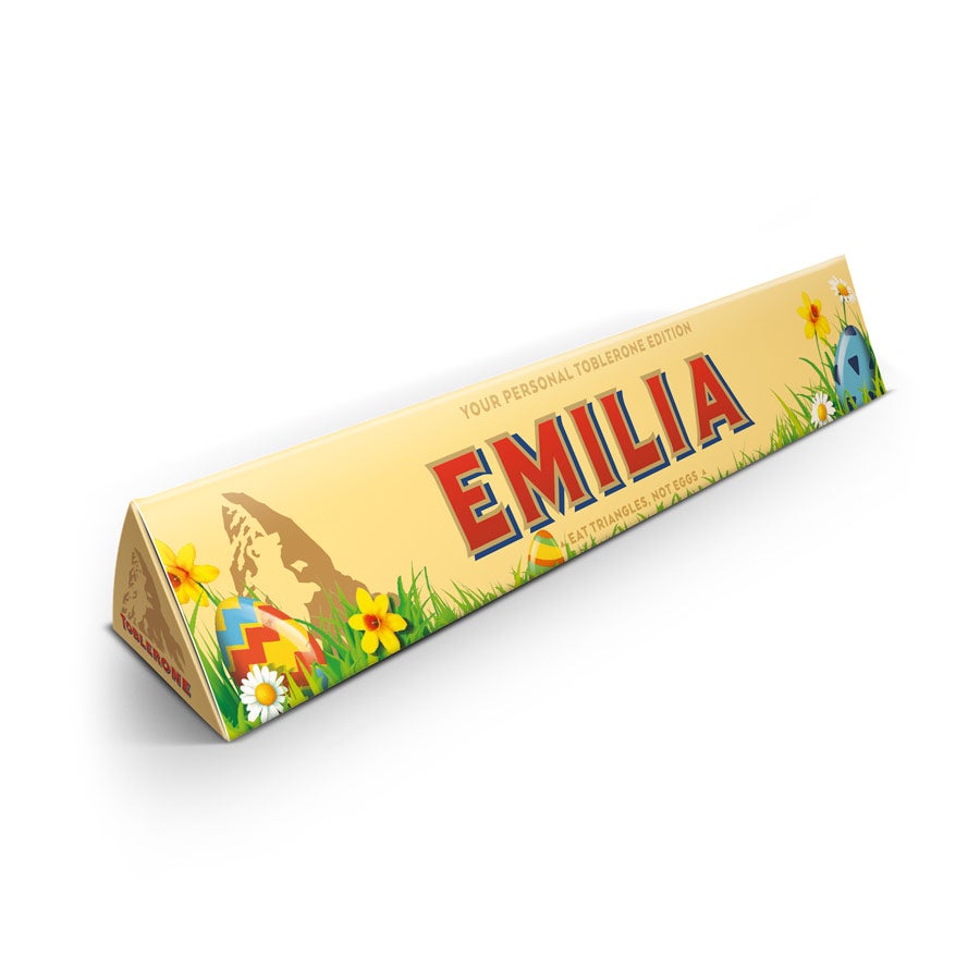 Barra de chocolate Toblerone personalizada para a Páscoa com o nome Emilia no embrulho, decorada com ovos e flores