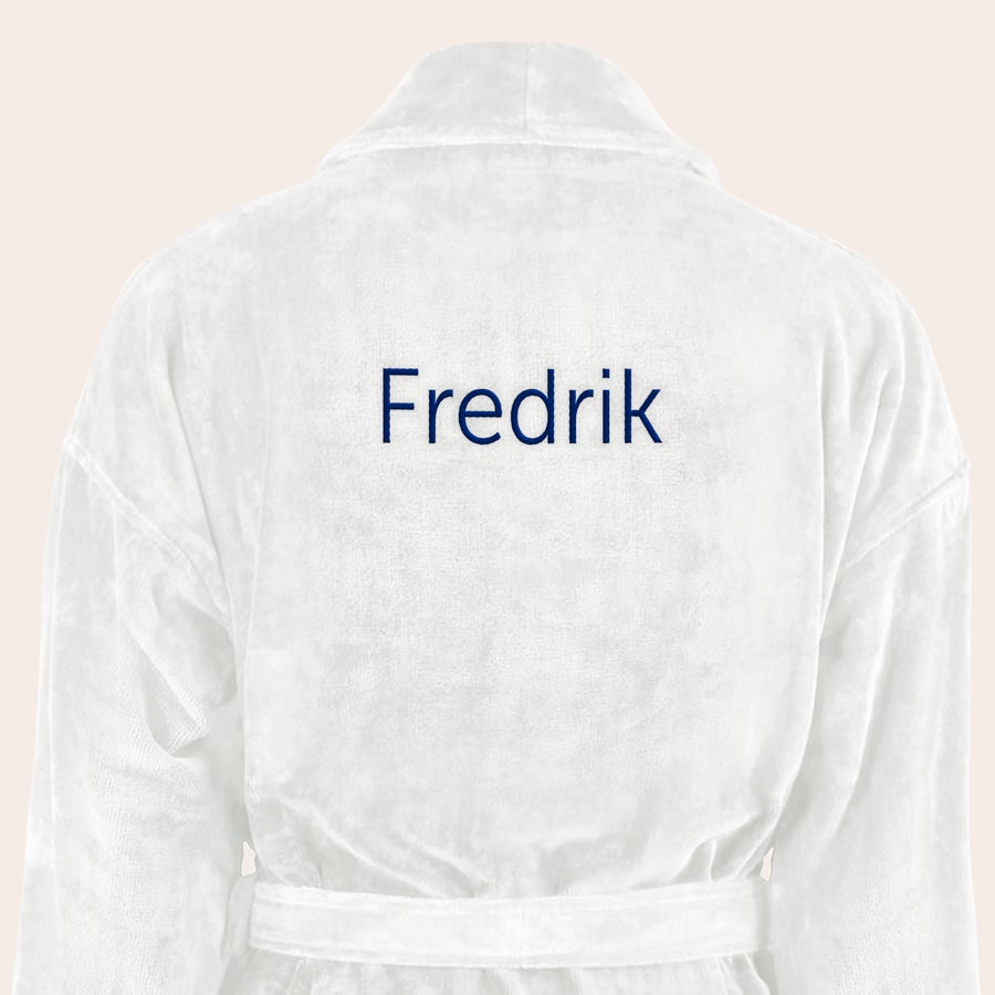 Badekåpe for menn med navn Hvit, myk badekåpe brodert med navnet Fredrik i mørkeblå tråd som en personlig gave.