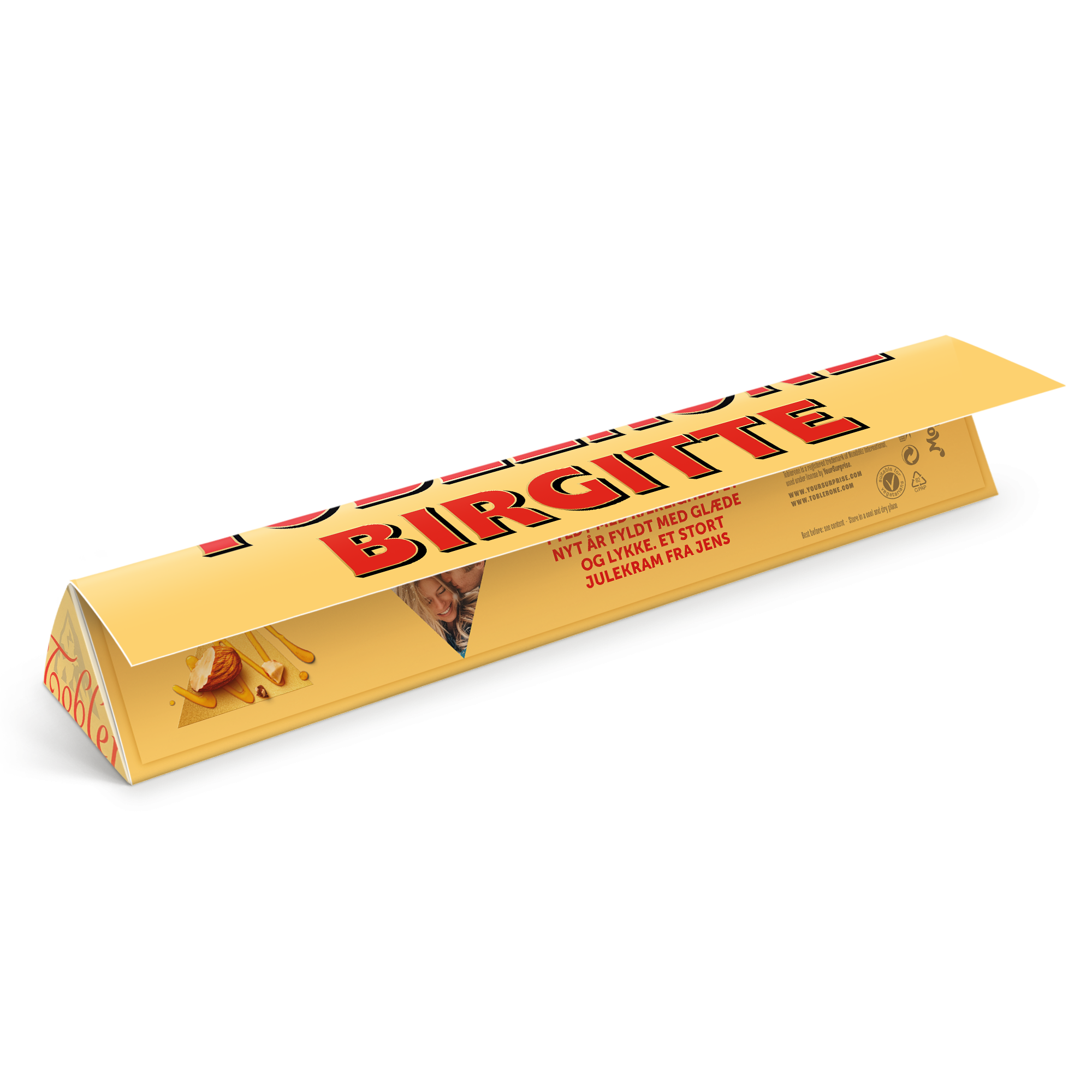 Personlig Toblerone i gul indpakning med navnet BIRGITTE trykt på og et billede af et par samt teksten NYT ÅR FYLDT MED GLÆDE OG LYKKE. ET STORT JULEKRAM FRA JENS. Skab din egen Personaliseret Toblerone med navn og billede.