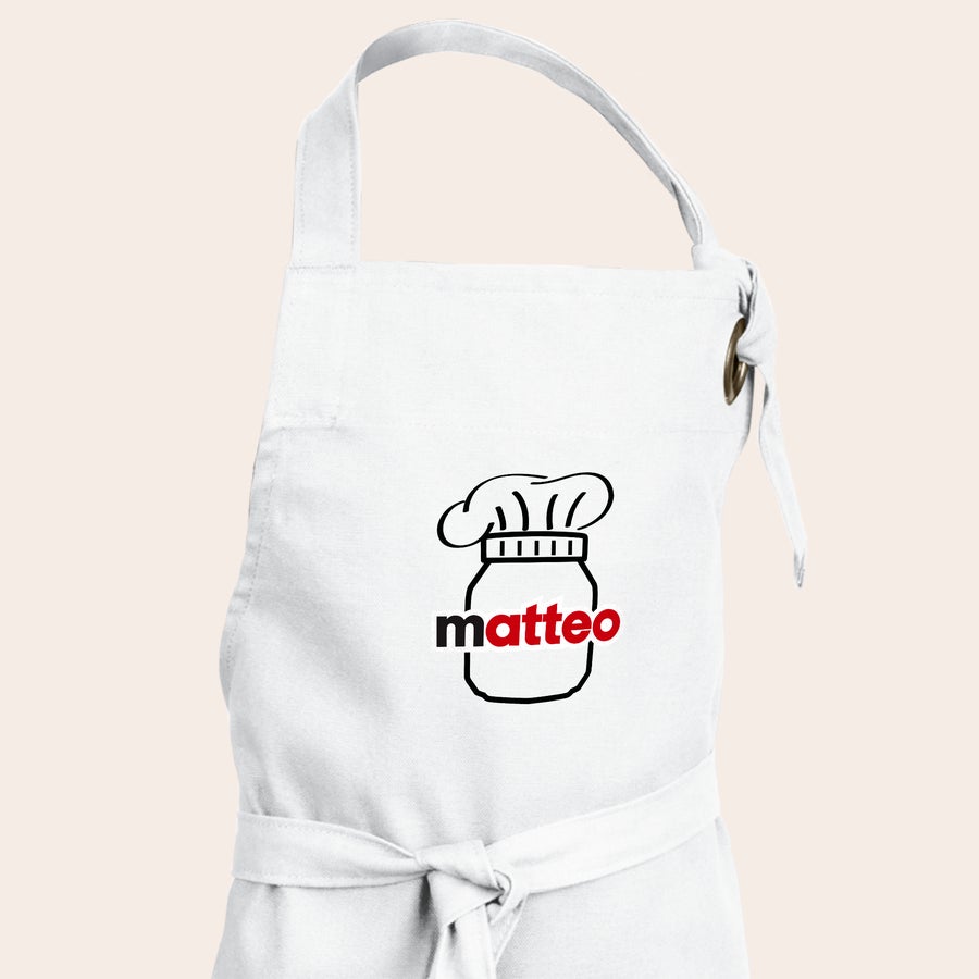 nutella®-Geschenkset - Backspaß Weiße Kinderschürze, bedruckt mit dem Namen Matteo in Rot und einer schwarzen Kochmütze über einem Glas Nutella