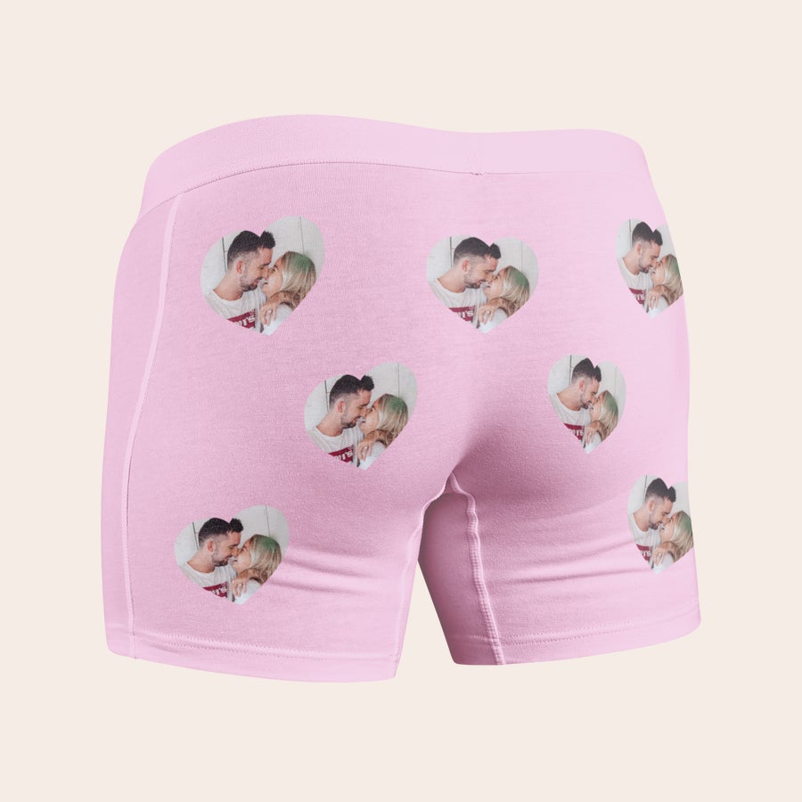 Boxer med bilde Rosa boksershorts med flere gjentatte hjerteformede bilder av et par som kysser, trykt for å overraske.