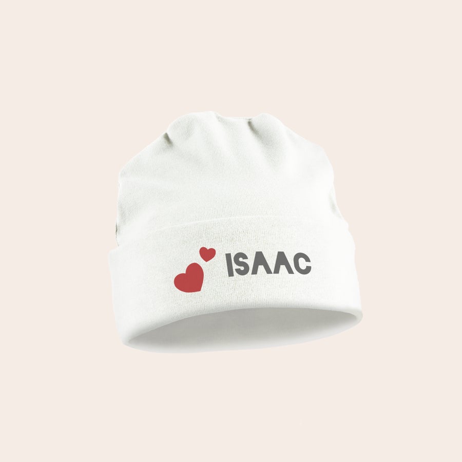 Cămașă pentru bebeluși personalizată Pălărie personalizată pentru bebeluși de culoare albă, imprimată cu numele ISAAC și două inimioare roșii.