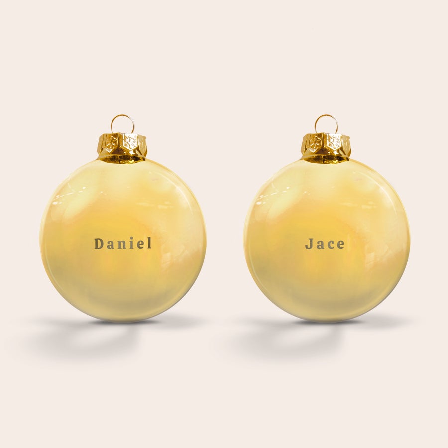 Bolas de Navidad - Cristal Dos bolas navideñas de cristal grabadas con los nombres "Daniel" y "Jace", perfectas para personalizar.