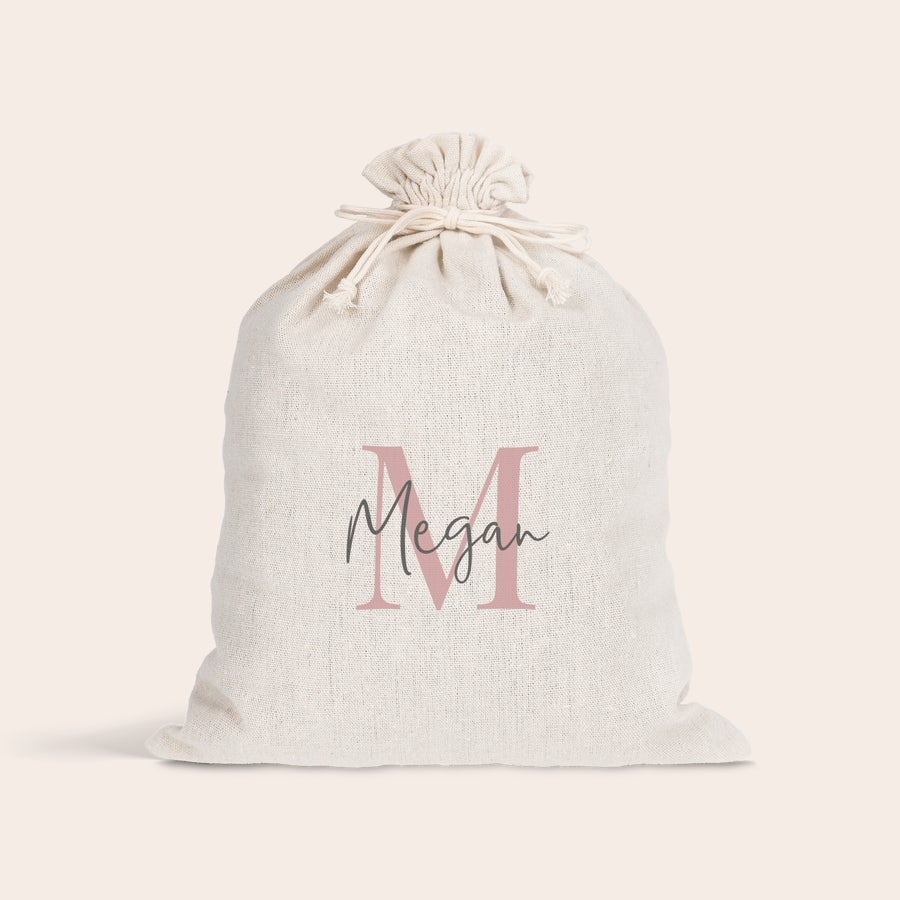 Pungă cadou cu cordon Pungă de cadou crem cu șnur, personalizată cu litera M roz și numele Megan, pentru a face Paștele special.