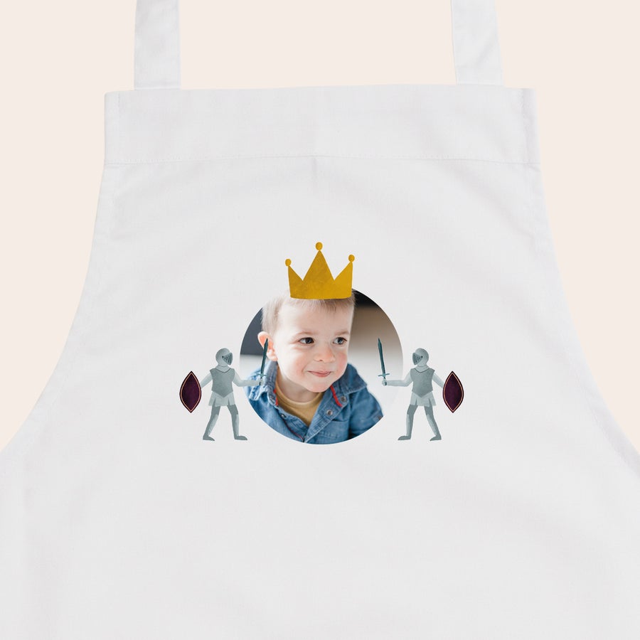 Kinderschort met naam Wit gepersonaliseerd kinderschort met foto van jongetje als prins, bedrukt met twee ridders en een kroon.