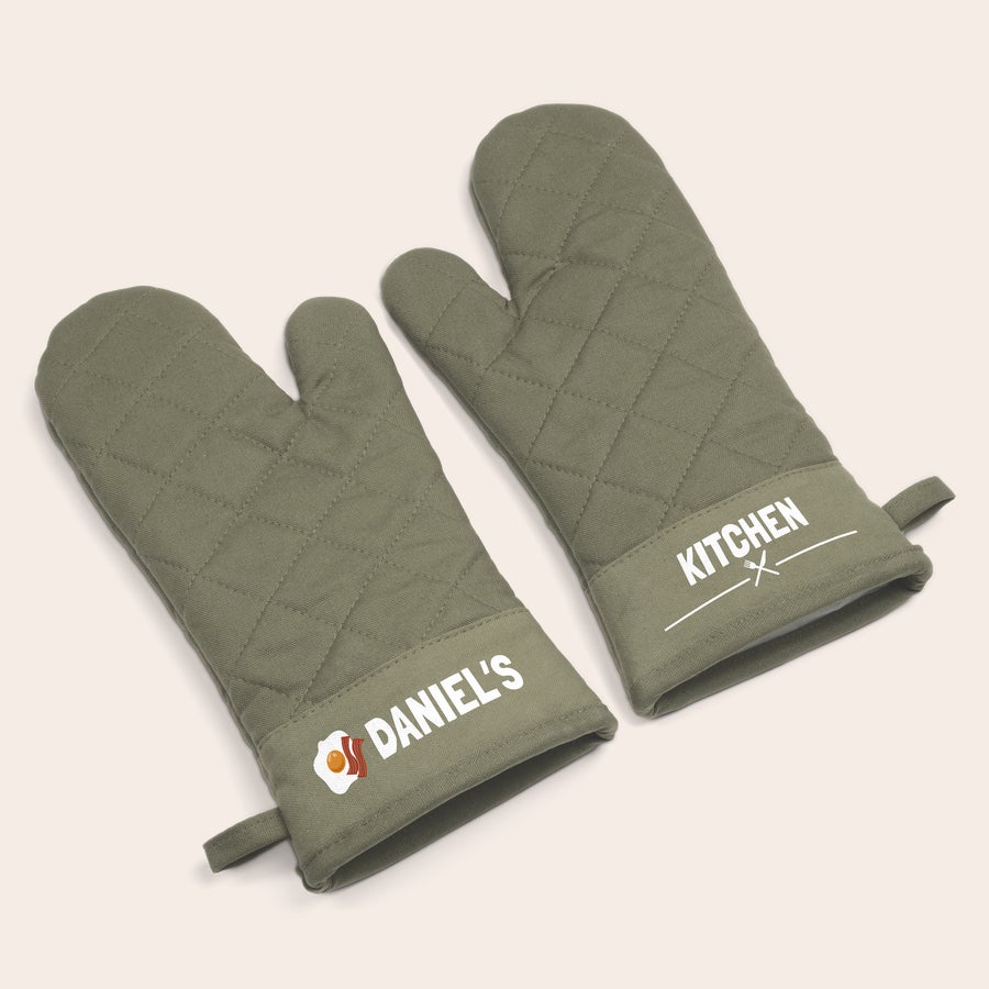 Set de guantes para horno personalizados Un par de guantes para horno personalizados de color verde oliva con texto impreso para cocinar.