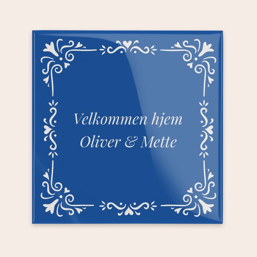 Traditionel Tegl Blå keramisk flise med personlig tekst "Velkommen hjem Oliver & Mette" og hvide dekorative mønstre i hjørnerne