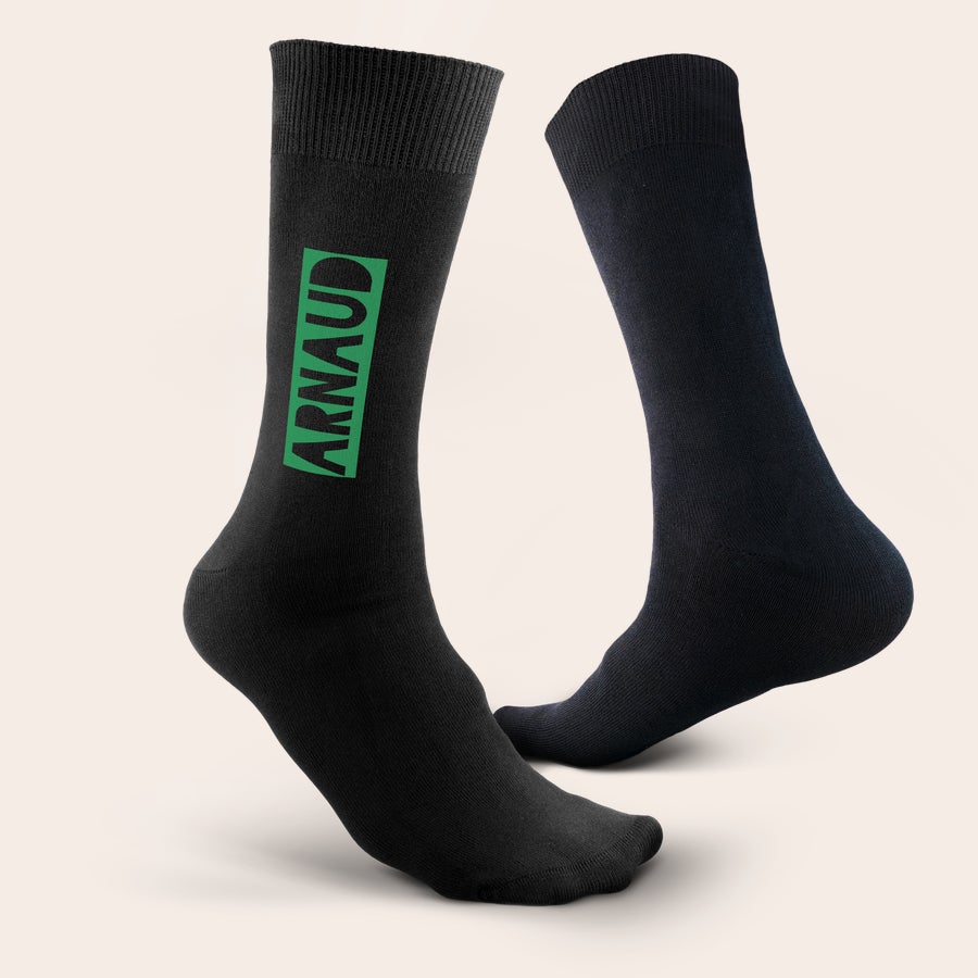 Chaussettes personnalisées prénom Chaussettes noires personnalisées avec le prénom Arnaud imprimé en vert vif sur le côté.