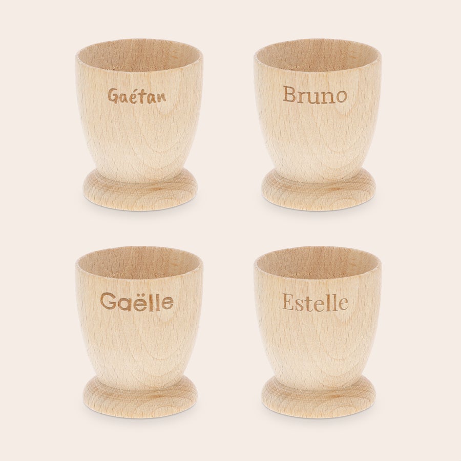 Coquetier personnalisé Quatre coquetiers personnalisés en bois de hêtre gravés avec les noms Gaétan Bruno Gaëlle Estelle