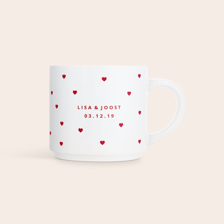 Stapelbare mokken bedrukken Witte stapelbare fotomok met kleine rode hartjes, bedrukt met de namen Lisa & Joost en de datum 03.12.19
