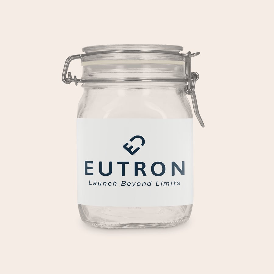 Glasskrukke med lokk - personlig Glasskrukke med lokk, 1 liter, personlig tilpasset med en hvit etikett og "EUTRON Launch Beyond Limits"-logo.