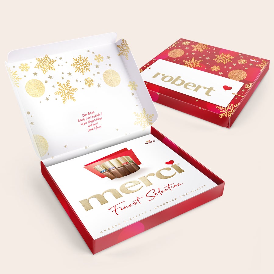 Merci chocolate with personalised card - 250 grams Merci chocolate with personalised card - 250 grams in a red box with golden snowflakes. The card is printed with a custom message and