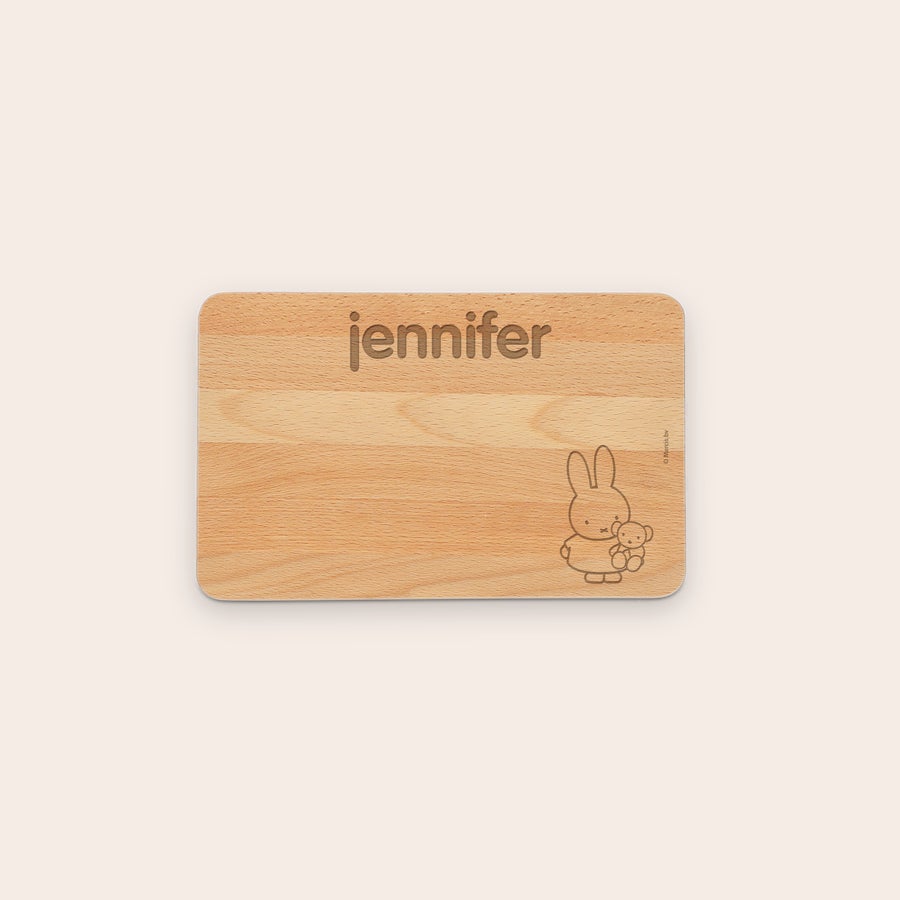 Skärbräda trä gravyr En inristad träbrödskiva med namn Jennifer och en bild på Miffy som kramar en nalle.