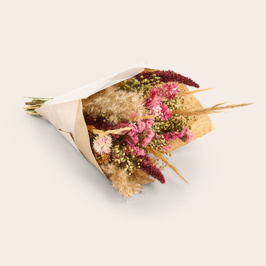 Droogbloemen cadeau Een prachtig boeket droogbloemen in kraft papier met een gepersonaliseerde kaart, geschikt als cadeau.