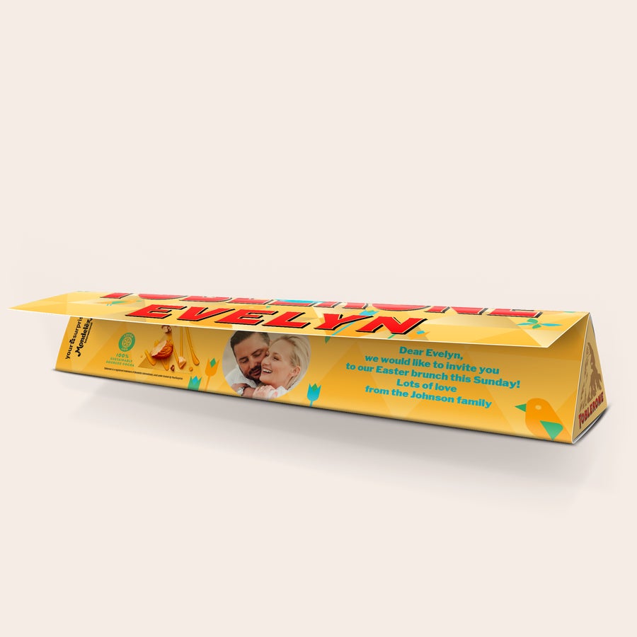 Toblerone personalizat - Paște Bar Toblerone de Paște personalizat cu numele Evelyn, o fotografie de cuplu și un mesaj, imprimat pe ambalajul galben cu design festiv.