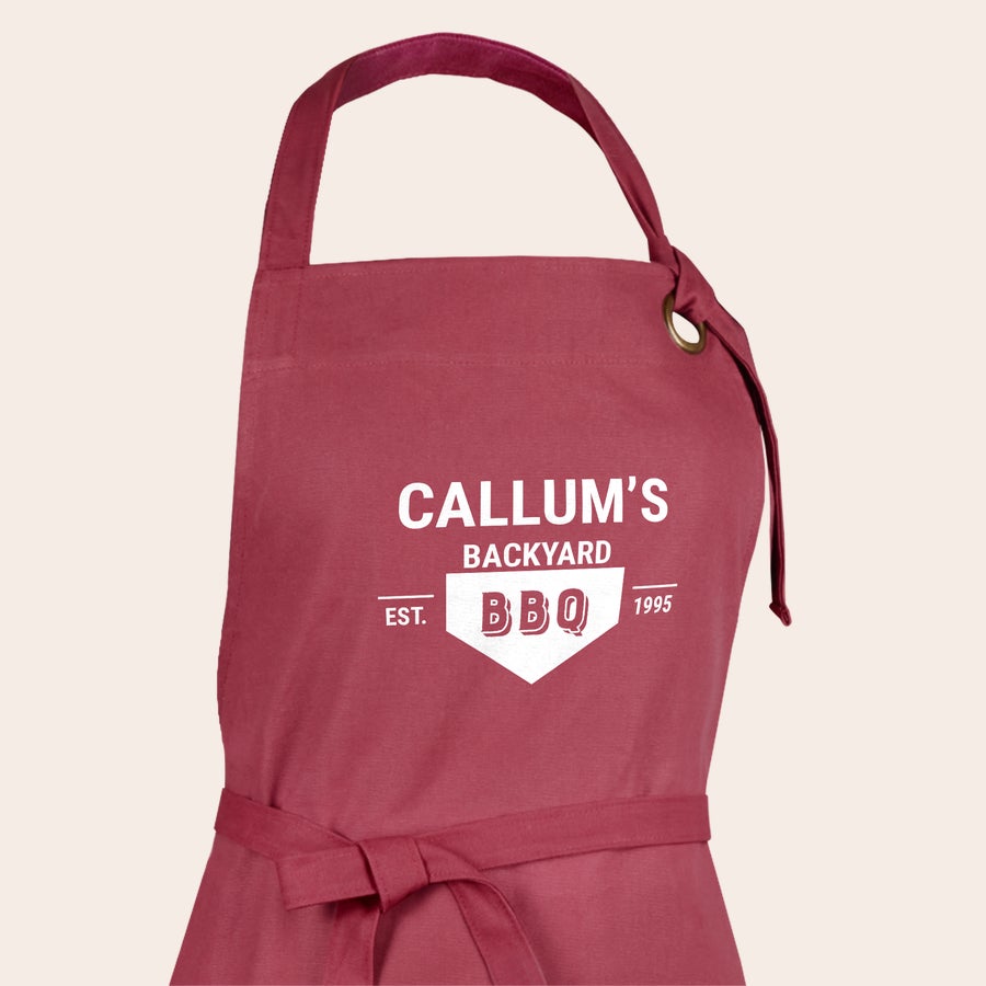 Predpasnik Bordo personaliziran predpasnik z napisom "Callum's Backyard BBQ Est. 1995", natisnjen z vašim dizajnom