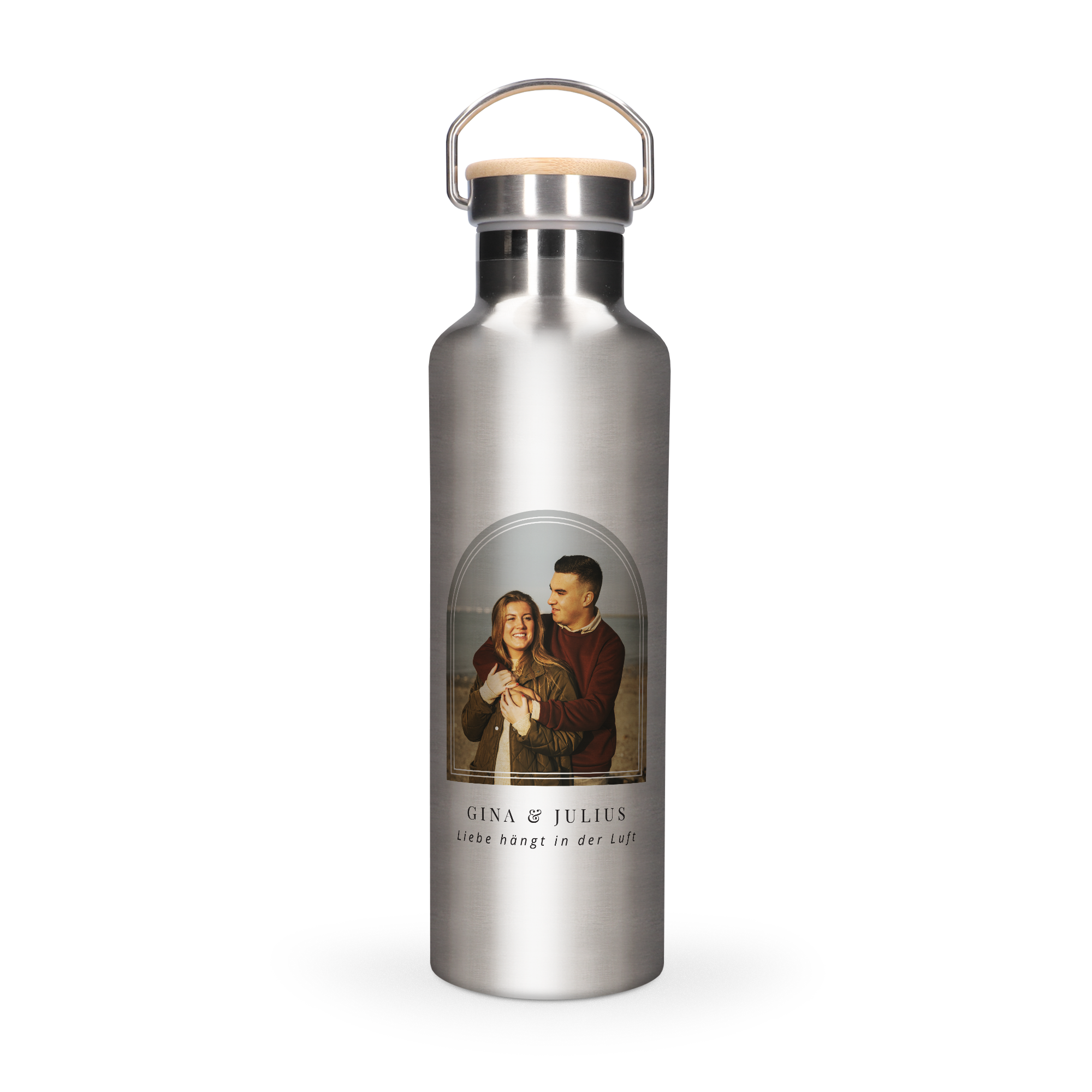 Edelstahl Trinkflasche mit Bambusverschluss, bedruckt mit einem Pärchenfoto und dem Text "Gena & Julius Liebe hängt in der Luft" für deine Trinkflasche mit Namen.
