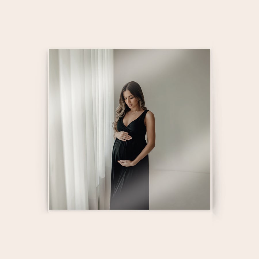 Foto en acrílico Foto en acrílico personalizada mostrando a una mujer embarazada en un vestido negro, impresa con una imagen personal.
