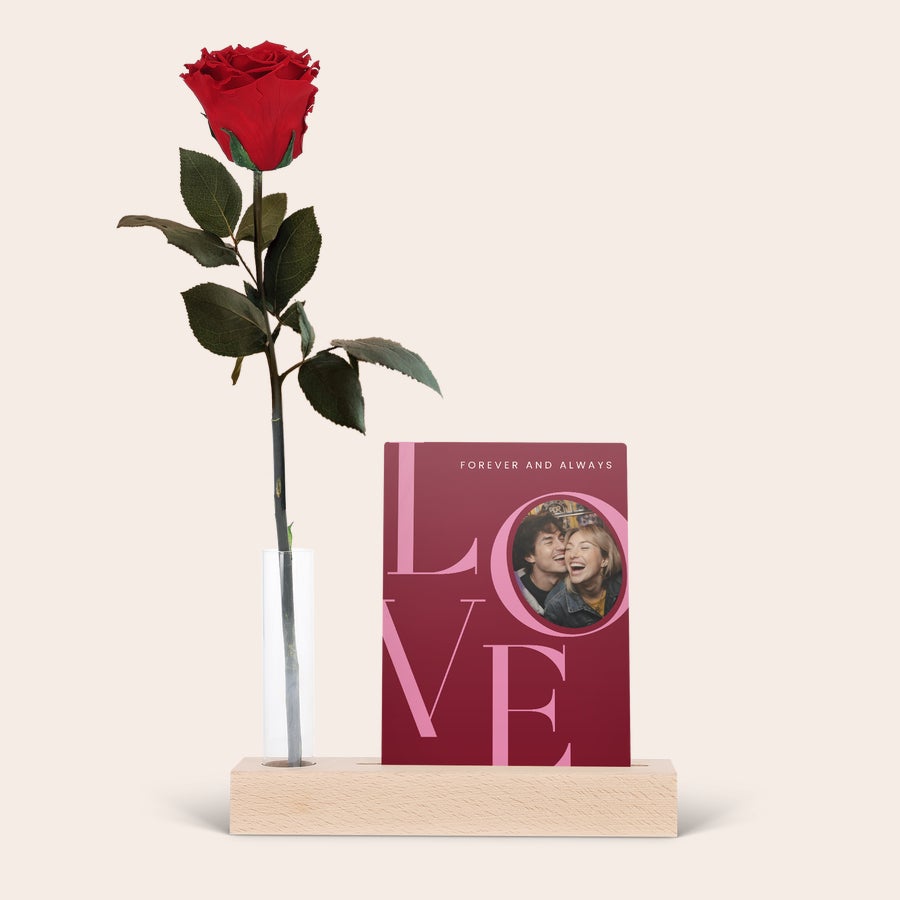 Infinity rose s stojalom za fotografije Infinity Rose s stojalom za fotografije, z rdečo vrtnico v vazi in natisnjeno sliko para na plošči z napisom LOVE