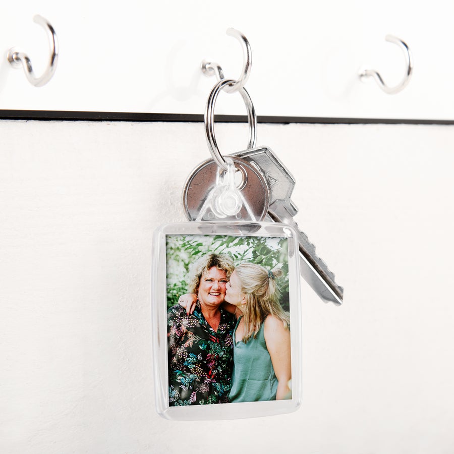 Sleutelhanger met logo Sleutelhanger met gepersonaliseerde foto van twee vrouwen, bedrukt met een eigen ontwerp om een unieke set sleutelhangers te maken.