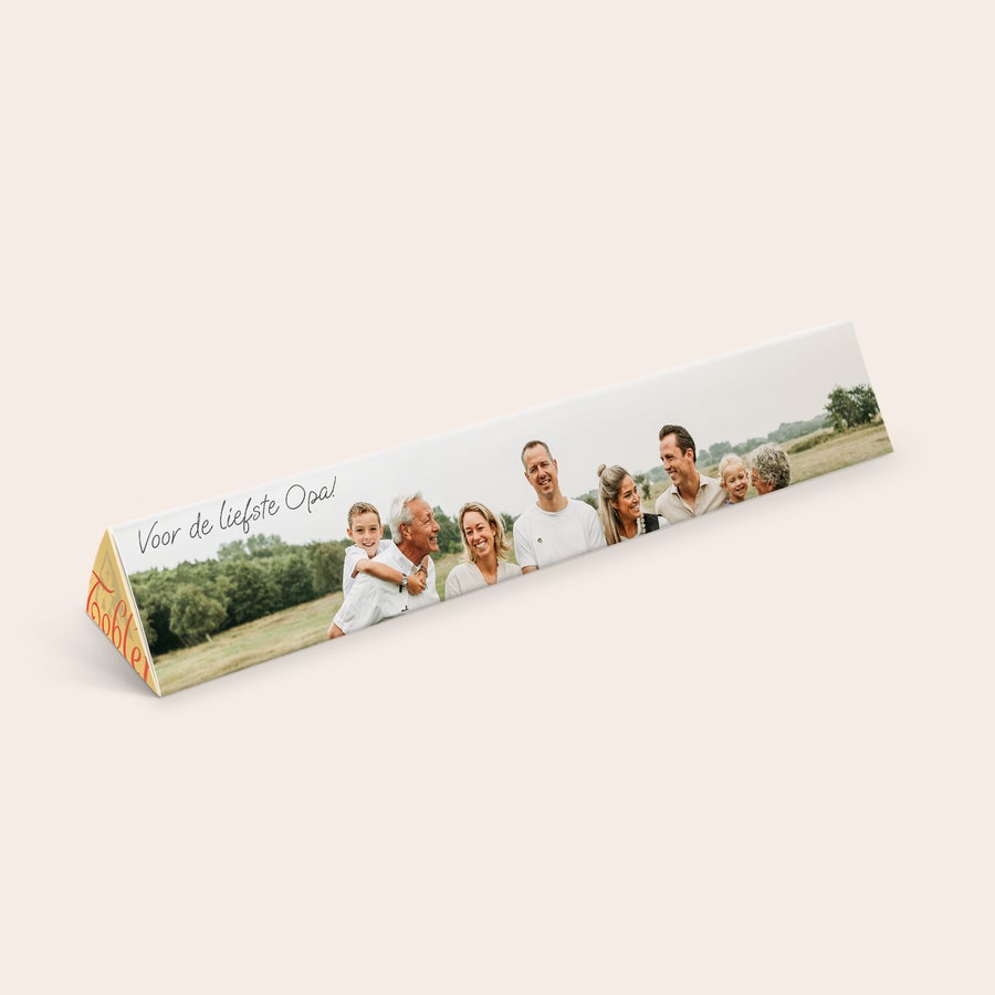 Toblerone met naam Gepersonaliseerde Toblerone chocoladereep met familie foto en tekst "Voor de liefste Opa!" bedrukt op de wikkel