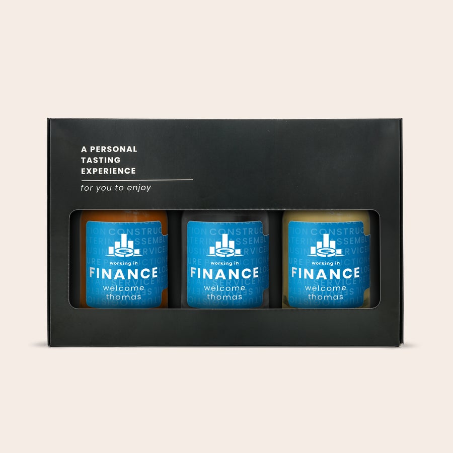 Mini cata de alcohol: vodka, ron y whisky Set de cata de alcohol en miniatura personalizado con 3 botellas de vodka, ron y whisky con etiquetas de finanzas impresas, incluyendo el texto "welcome thomas", presentado en una caja negra.