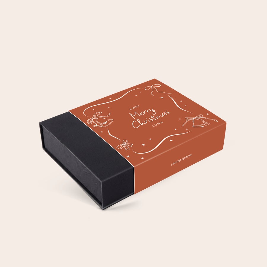 Caja de bombones de lujo - Navidad Caja de chocolates navideños personalizados con mensaje impreso "A Very Merry Christmas Luna" sobre fondo rojo y campanas festivas.