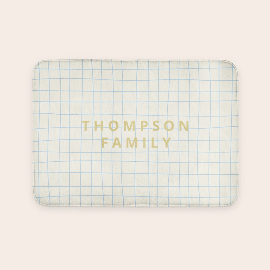 Personoitu kylpymatto - 70 x 50 cm Personoitu kylpymatto Thompson Family -tekstillä ja sinisellä ruutukuvioinnilla, tekee kylpyhuoneesta henkilökohtaisen keitaan.