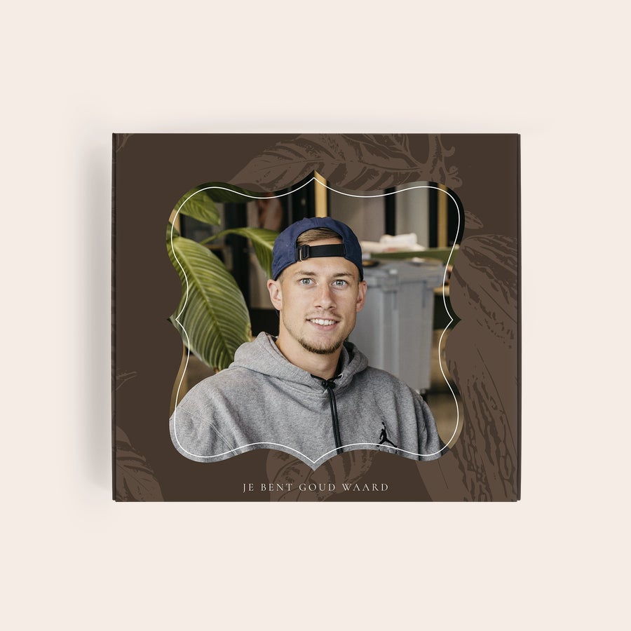 Milka Pralines Thank You Gepersonaliseerde Milka giftbox met foto van een lachende man in een blauwe pet en grijs vest en de tekst "JE BENT GOUD WAARD" bedrukt op de doos.