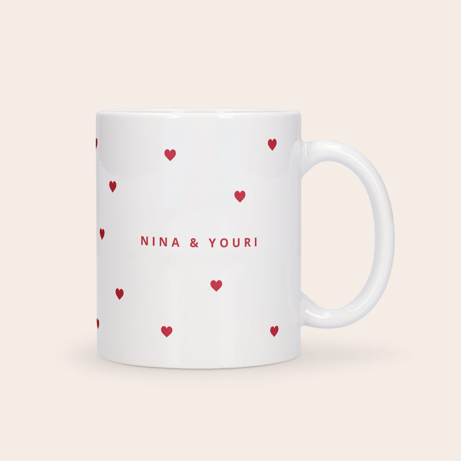 Mug amour personnalisé Tasse amour festive blanche imprimée de cœurs rouges et des prénoms NINA & YOURI pour célébrer l'amour