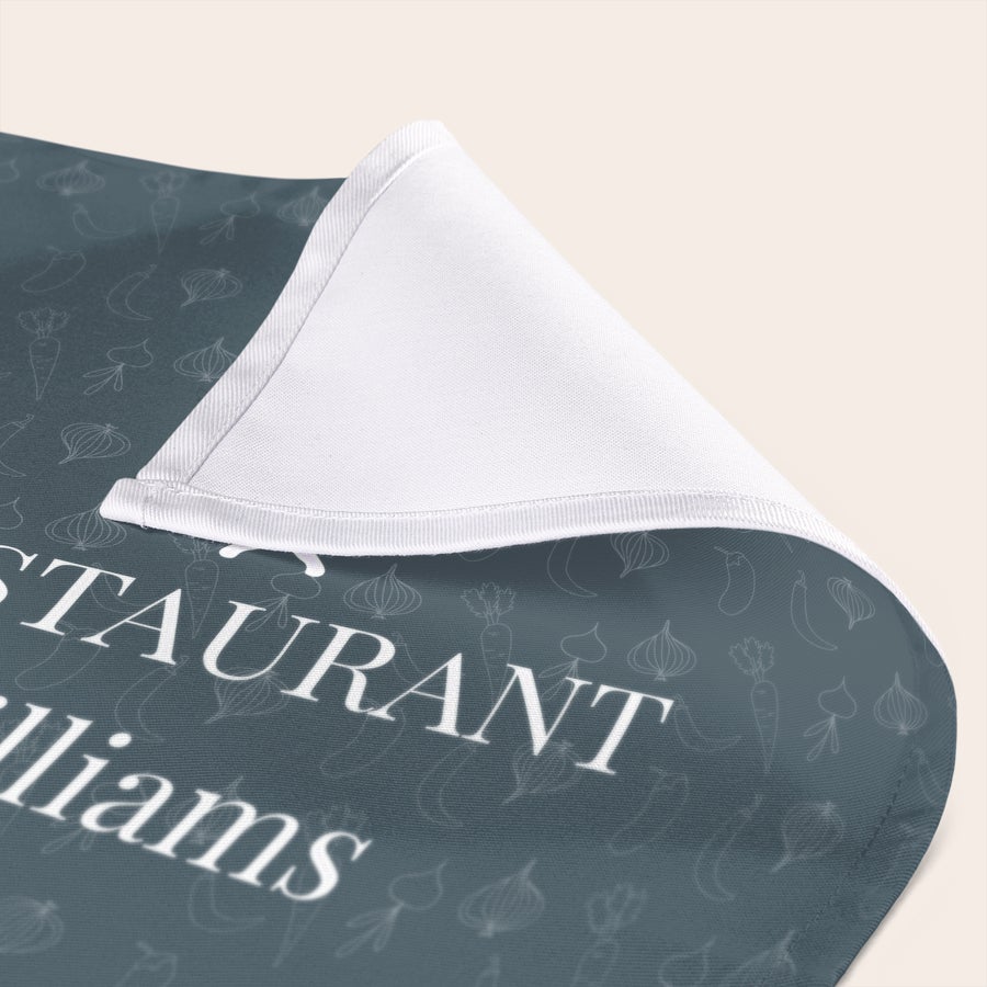 Personlige servietter En grå serviett med trykk, hvite matikoner og teksten "Restaurant Williams" kan gjøres personlig.