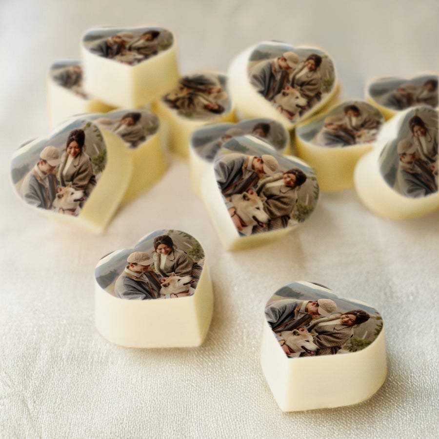 Chocolade traktatie met foto Hartvormige fotopralines van witte chocolade, bedrukt met een foto van een stel en hond.