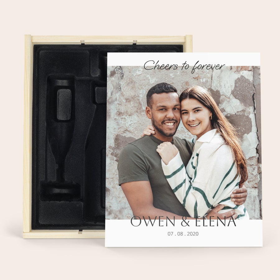 Egyedi pezsgőspohár fa díszdobozban Egy deluxe fa tok személyre szabott nyomattal egy üveg és 2 pezsgőspohár számára, "Cheers to forever" felirattal, Owen és Elena nevekkel, valamint 2020.08.07 dátummal.