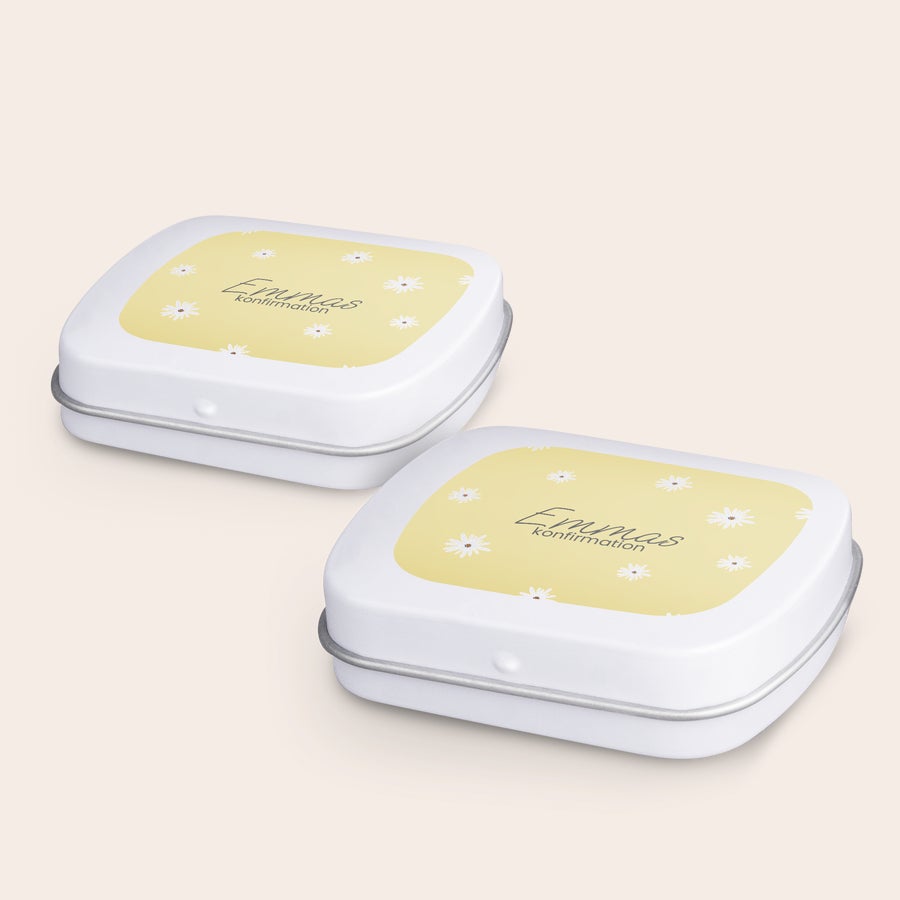 Pepparmint i  personliga burk Två vita burkar med personliga pepparmyntor med texten Emmas Konfirmation och vitt tusensköna-mönster tryckt på locket.