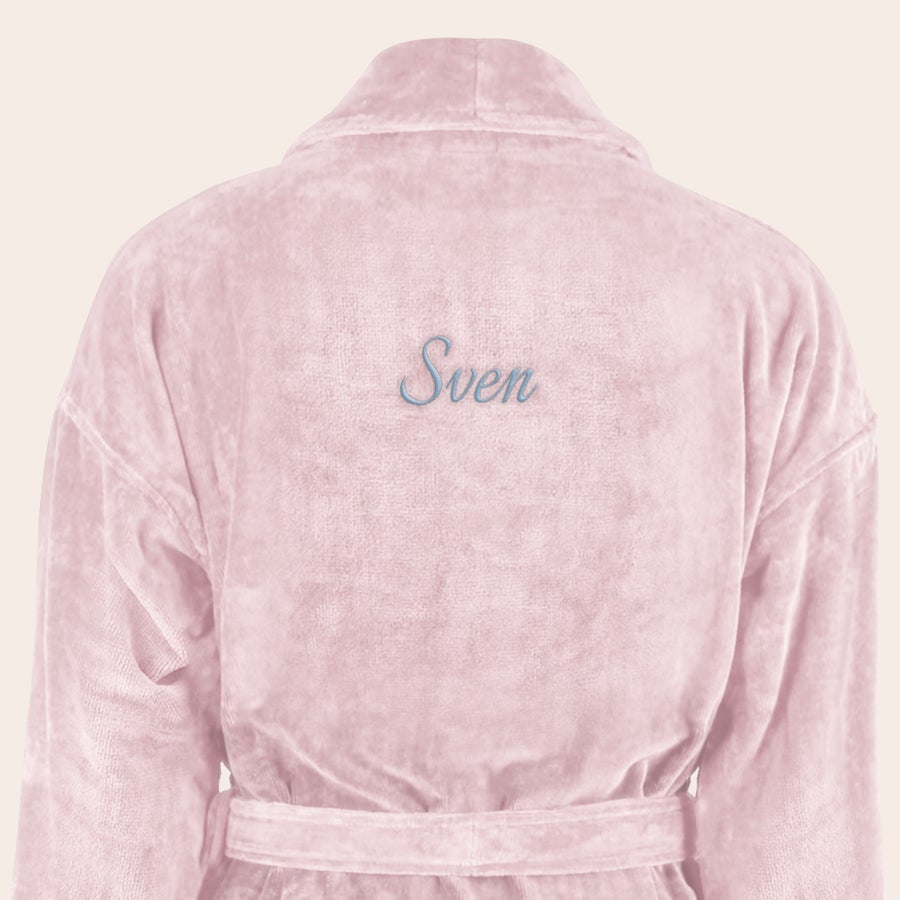 Badrock Herr med namn Mjuk morgonrock i rosa färg, broderad med namnet "Sven" i ljusblå tråd på ryggen, med knytband i midjan.