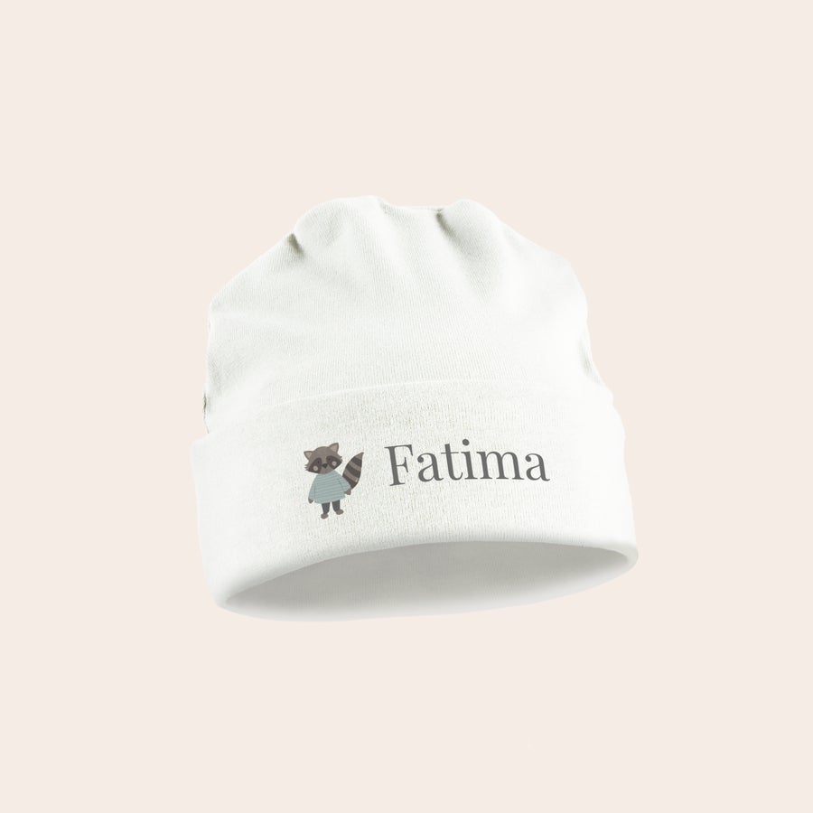 Vauvan myssy Suloinen vauvan myssy valkoisena, jossa kirjailtuna harmaa pesukarhu ja nimi Fatima.